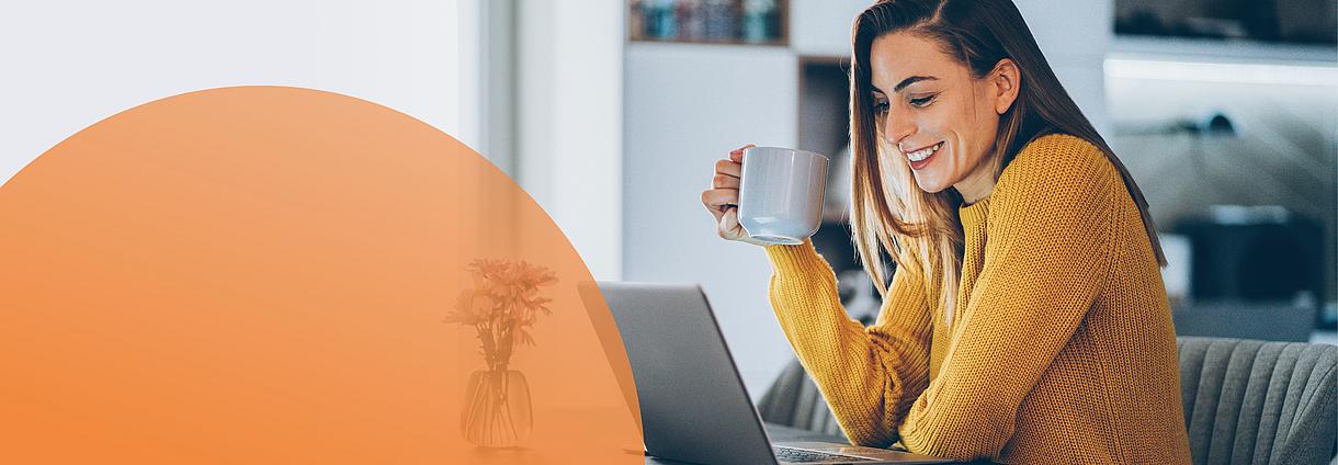 Junge Frau mit Kaffeetasse am Laptop