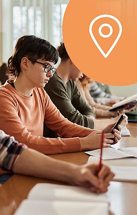 Icon Kartennadel, Schüler am Smartphone im Klassenraum